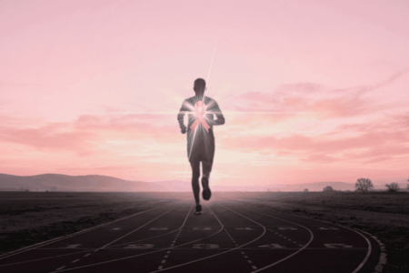 Coureur au lever du soleil portant un ruban rose, symbole d'Octobre Rose et du dépassement de soi